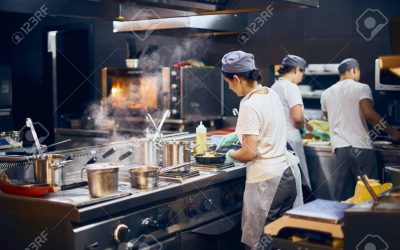 the team of cooks backs in the work in the modern kitchen, the workflow of the restaurant in the kitchen. Copy space for text.